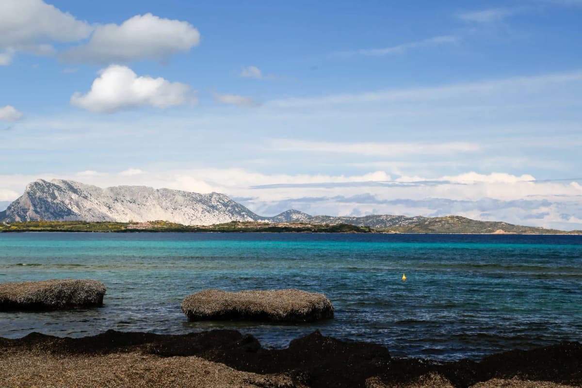 Stunning view of San Teodoro beach with turquoise waters and mountainous backdrop.